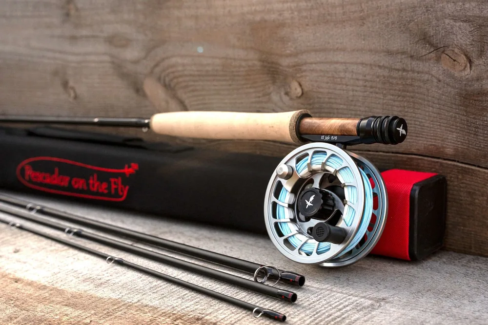 The El Jefe v2 combo laid out on grey planks: the black Cordura square tube with its red Pescador on the Fly script, the butt section with cork grip and mounted El Jefe 5/6 reel, and the three remaining sections with red wrapped guides.